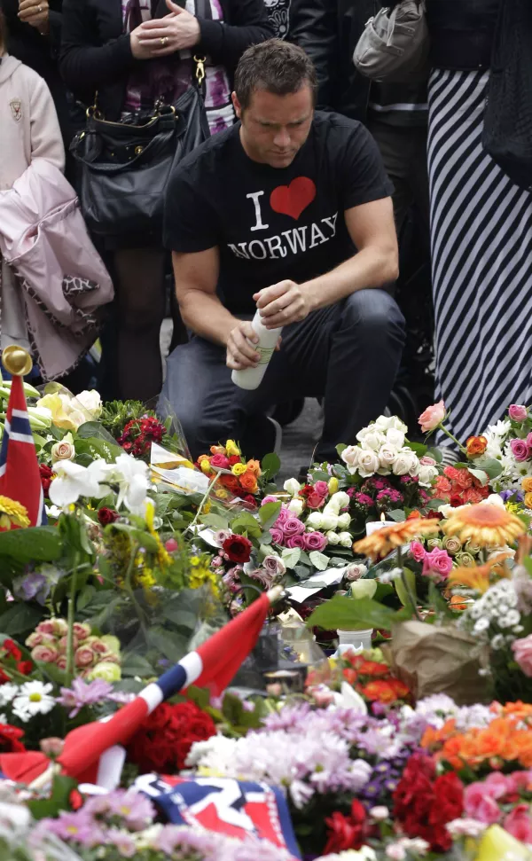 A man lights a candle at the massive flower field laid in memory of victims of Friday's twin attacks in front of the Oslo Cathedral in Oslo, Norway, Monday, July 25, 2011. A judge denied Anders Behring Breivik the public stage he wanted to air his anti-Muslim rants and call for revolution on Monday, ruling that the first hearing for the man who has confessed to Norway's twin terror attacks be held behind closed doors. (AP Photo/Frank Augstein)