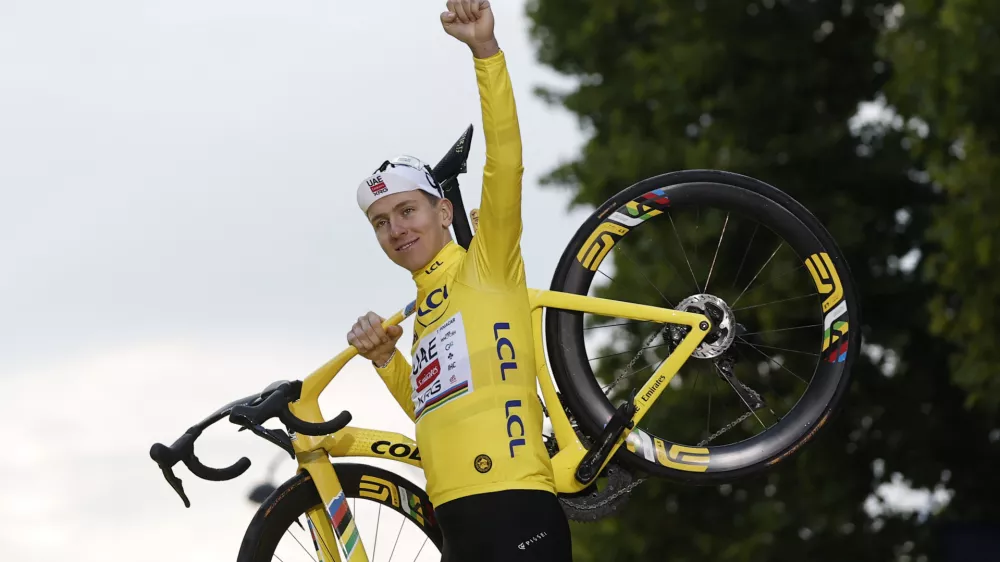 Cycling - Tour de France - Stage 21 - Mantes-la-Ville to Paris - Paris, France - July 27, 2025 UAE Team Emirates XRG's Tadej Pogacar celebrates on the podium with his bike while wearing the yellow jersey after winning the Tour de France REUTERS/Benoit Tessier