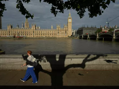A woman walks by the River Thames with a view of Big Ben and the Houses of Parliament London, Britain, July 28, 2025. REUTERS/Jaimi Joy