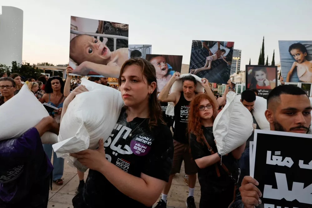 Demonstrators carry sacks of flour, during a protest demanding an end to the war in Gaza and the release of all hostages, in Tel Aviv, Israel, July 22, 2025. REUTERS/Ammar Awad