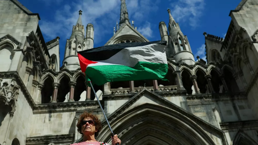 A person holds a Palestinian flag outside the High Court on the day of a hearing about the banned pro-Palestinian campaign organisation Palestine Action, in London, Britain, July 21, 2025. REUTERS/Isabel Infantes