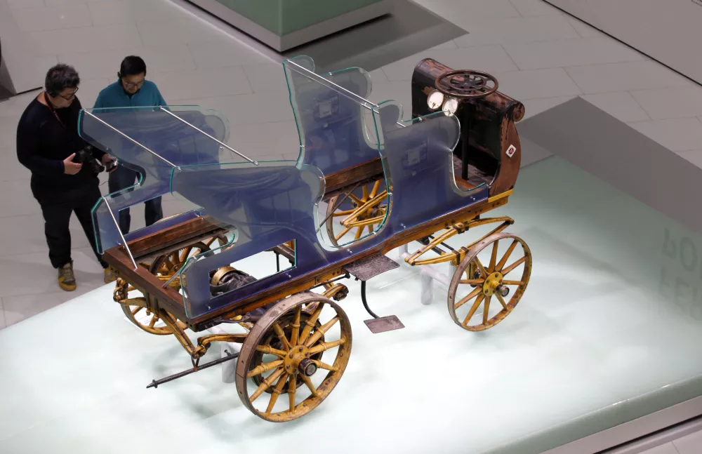 Visitors look at the world's very first Porsche from 1898 "Egger-Lohner-Elektromobil Modell C.2 Phaeton (P1)" at the museum of German sports car manufacturer Porsche in Stuttgart February 6, 2014. The vehicle was designed and built by Ferdinand Porsche in 1898 and has a top speed by 35 km per hour. Picture taken on February 6, 2014. REUTERS/Michaela Rehle (GERMANY - Tags: BUSINESS TRANSPORT)
