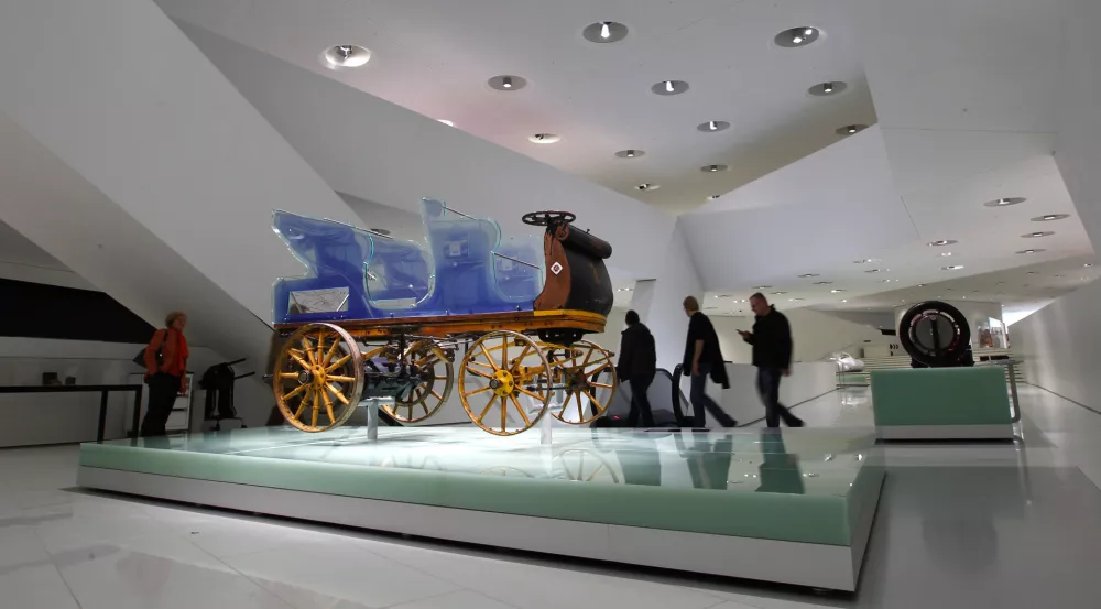 Visitors look at the world's very first Porsche from 1898 "Egger-Lohner-Elektromobil Modell C.2 Phaeton (P1)" at the museum of German sports car manufacturer Porsche in Stuttgart February 6, 2014. The vehicle was designed and built by Ferdinand Porsche in 1898 and has a top speed by 35 km per hour. Picture taken on February 6, 2014. REUTERS/Michaela Rehle (GERMANY - Tags: BUSINESS TRANSPORT)