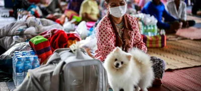 Juam, 50 sits next to her dog "Krati" inside a temporary shelter in Srisaket province, after Thailand and Cambodia exchanged heavy artillery fire for a second day on Friday as border fighting intensified and spread, while Cambodia's leader said Thailand had agreed to a Malaysian ceasefire proposal but then backed down, Thailand, July 26, 2025. REUTERS/Athit Perawongmetha
