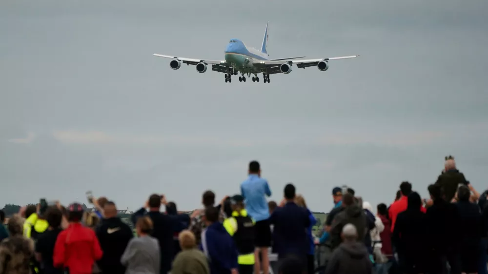 Trump supporters watch on as a plane carrying US President Donald Trump arrives at Prestwick Airport, before he begins his five-day private trip to the country, Friday July 25, 2025. (Jane Barlow/PA via AP)
