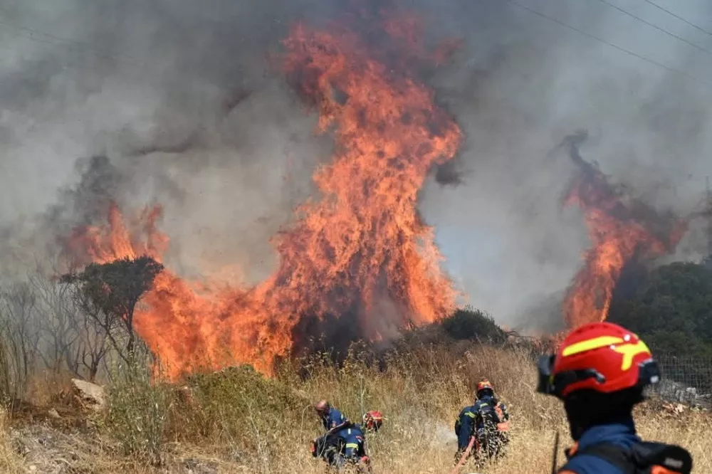 Firefighters try to extinguish flames as a wildfire burns on the island of Kythira, Greece, July 26, 2025. REUTERS/Stamatina Tamvaki