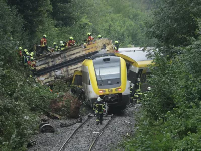 27 July 2025, Riedlingen: Rescue workers search for passengers in a derailed train. Several people have been killed and many others injured after a passenger train derailed in Biberach district between Zweifaltendorf and Zell in south-western Germany. Photo: Thomas Warnack/dpa