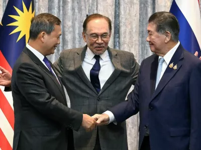 Malaysia's Prime Minister Anwar Ibrahim reacts as Cambodia's Prime Minister Hun Manet and Thailand's acting Prime Minister Phumtham Wechayachai shake hands following a press conference, on the day of mediation talks on the Thailand–Cambodia border conflict, in Putrajaya, Malaysia July 28, 2025.  Mohd Rasfan/Pool via REUTERS