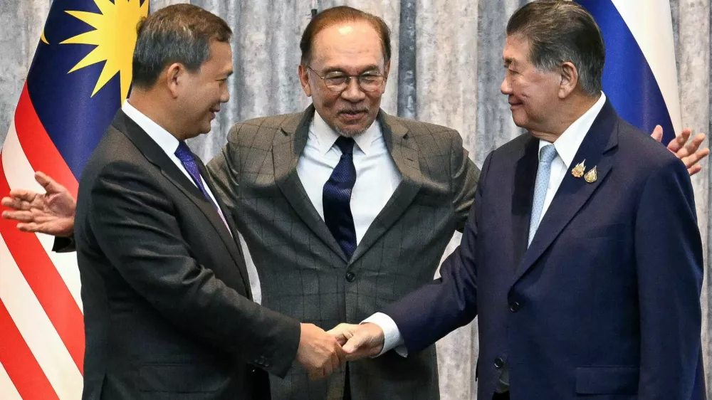 Malaysia's Prime Minister Anwar Ibrahim reacts as Cambodia's Prime Minister Hun Manet and Thailand's acting Prime Minister Phumtham Wechayachai shake hands following a press conference, on the day of mediation talks on the Thailand–Cambodia border conflict, in Putrajaya, Malaysia July 28, 2025.  Mohd Rasfan/Pool via REUTERS
