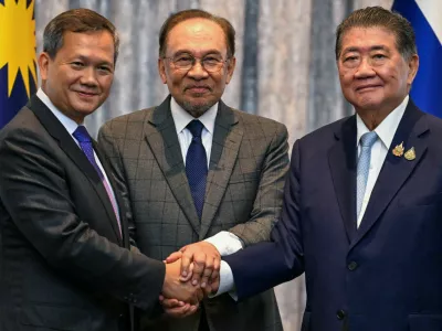 Cambodia's Prime Minister Hun Manet, Malaysia's Prime Minister Anwar Ibrahim and Thailand's acting Prime Minister Phumtham Wechayachai shake hands as they pose for photos following a press conference, on the day of mediation talks on the Thailand–Cambodia border conflict, in Putrajaya, Malaysia July 28, 2025.  Mohd Rasfan/Pool via REUTERS