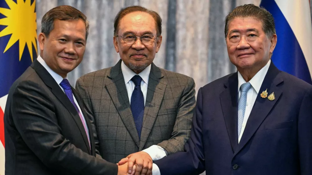 Cambodia's Prime Minister Hun Manet, Malaysia's Prime Minister Anwar Ibrahim and Thailand's acting Prime Minister Phumtham Wechayachai shake hands as they pose for photos following a press conference, on the day of mediation talks on the Thailand–Cambodia border conflict, in Putrajaya, Malaysia July 28, 2025.  Mohd Rasfan/Pool via REUTERS