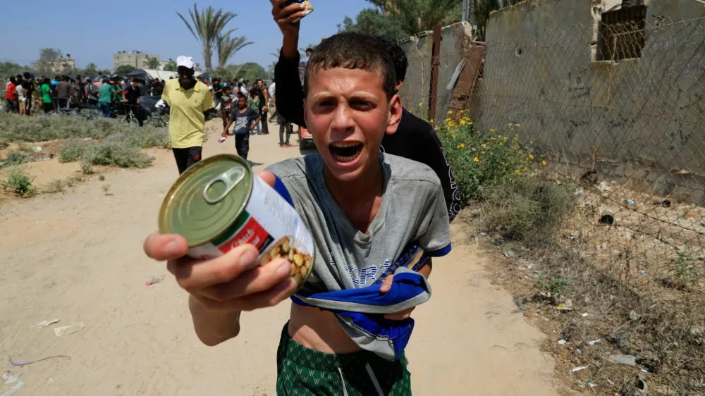 A Palestinian youth holds a can of chickpeas from an aid package dropped from an airplane, amid a hunger crisis, in Zawayda, in the central Gaza Strip, July 28, 2025. REUTERS/Hatem Khaled