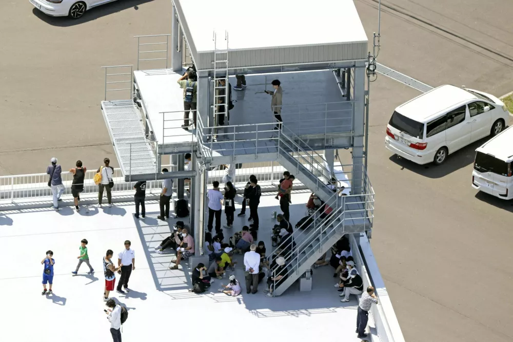 People evacuated are seen on the roof of the fire station building after Japan issued evacuation alert following major quake in Russia's Kamchatka Peninsula that triggered a tsunami warning, in Mukawa Town, Hokkaido, Japan July 30, 2025, in this photo taken by Kyodo. Kyodo/via REUTERS ATTENTION EDITORS - THIS IMAGE HAS BEEN SUPPLIED BY A THIRD PARTY. MANDATORY CREDIT. JAPAN OUT. NO COMMERCIAL OR EDITORIAL SALES IN JAPAN.