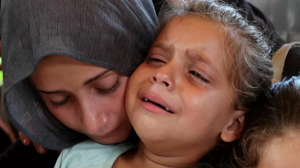 A woman and a child react during the funeral of Palestinians, who were killed by Israeli fire while trying to receive aid on Wednesday, and Palestinians who were killed in overnight Israeli airstrikes on tents, according to medics, at Nasser Hospital in Khan Younis, southern Gaza Strip, July 31, 2025. REUTERS/Ramadan Abed   TPX IMAGES OF THE DAY