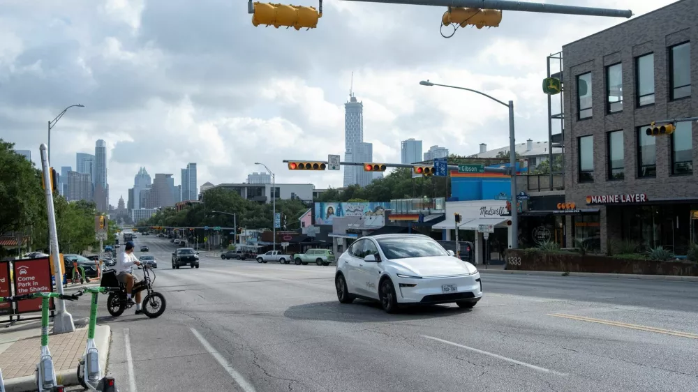 FILE PHOTO: A Tesla robotaxi drives on the street along South Congress Avenue in Austin, Texas, U.S., June 22, 2025. REUTERS/Joel Angel Juarez/File Photo
