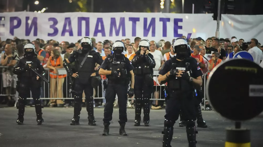 Riot police take positions between government supporters, seen in the background, and people taking part in a major anti-government rally pressing for an early election after nearly eight months of almost daily anti-corruption demonstrations that have shaken the populist government of President Aleksandar Vucic, in Belgrade, Serbia, Saturday, June 28, 2025. (AP Photo/Darko Vojinovic)