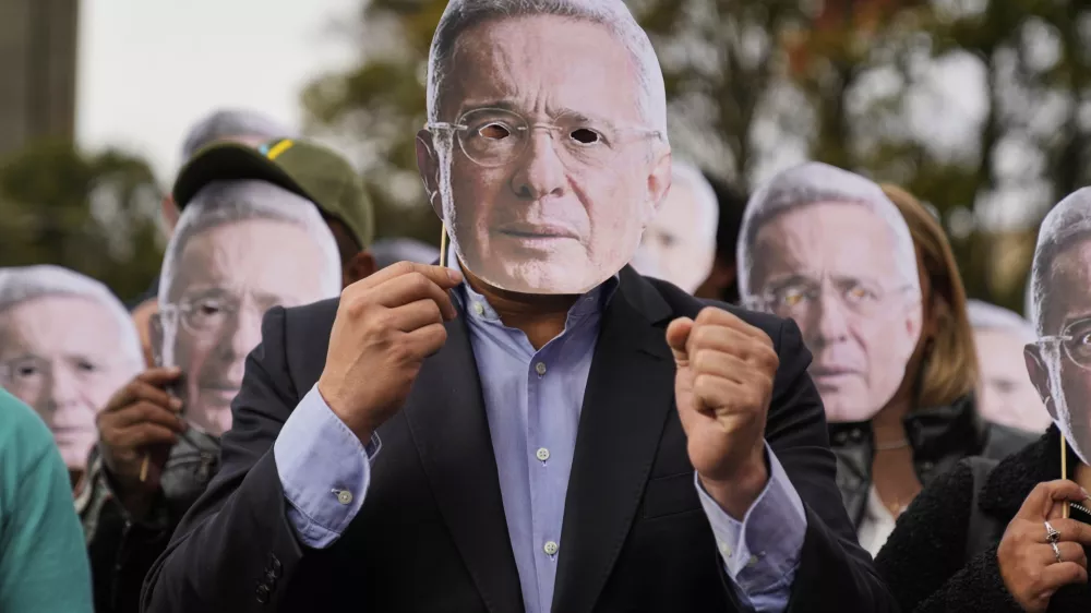 Supporters of former Colombian President Alvaro Uribe hold cutouts of his face outside the court where a verdict is expected in his trial for witness tampering in Bogota, Colombia, July 28, 2025. (AP Photo/Fernando Vergara)