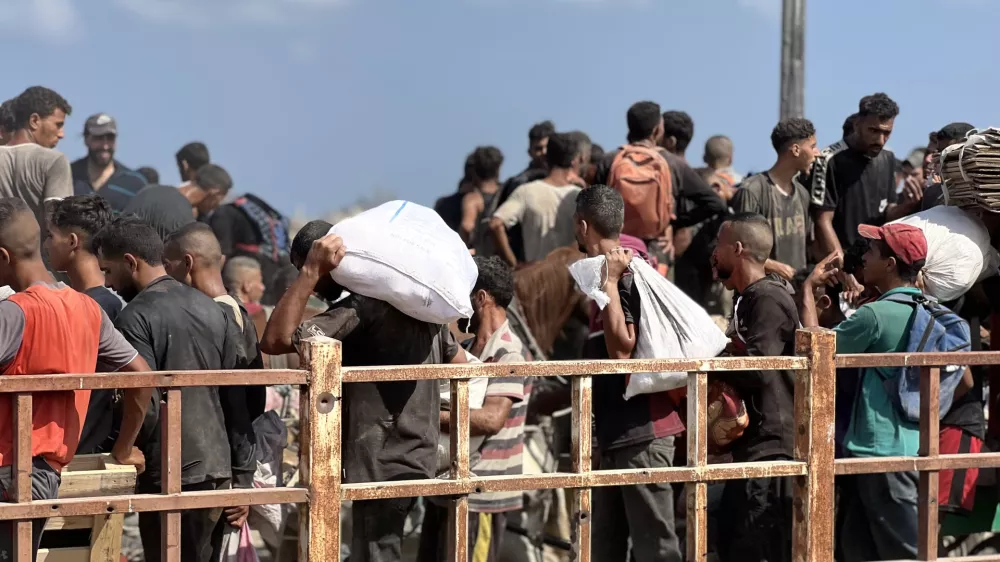 03 August 2025, Palestinian Territories, Nusairat: Palestinians carry aid supplies which they received from the U.S.-backed Gaza Humanitarian Foundation (GHF), in the central Gaza Strip. Photo: Belal Abu Amer/APA Images via ZUMA Press Wire/dpa