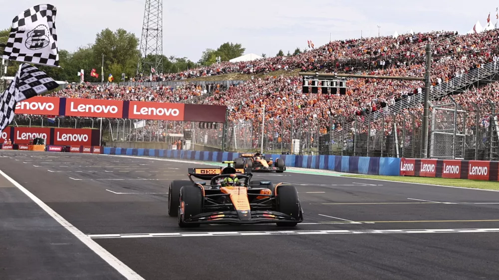 McLaren driver Lando Norris of Britain crosses the finish line to win the Hungarian Formula One Grand Prix race at the Hungaroring racetrack in Mogyorod, Hungary, Sunday, Aug. 3, 2025. (Anna Szilagyi/Pool Photo via AP)
