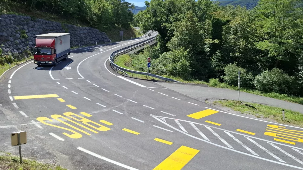 Cesta preko Rebernic, krizisce za Lozice.Novo zarisana avtobusna postaja sredi krizisca.