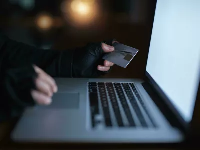 2M52K83 Secure yourself from becoming the next victim of fraud. an unrecognisable hacker using a laptop to hack into a credit account.