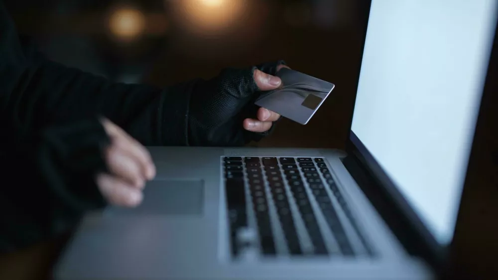 2M52K83 Secure yourself from becoming the next victim of fraud. an unrecognisable hacker using a laptop to hack into a credit account.