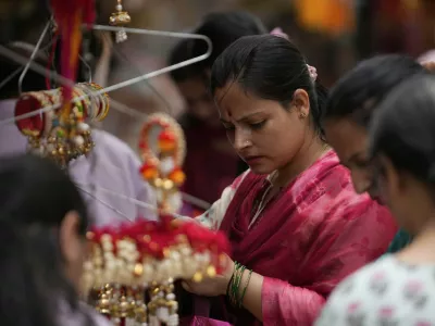 A woman shops for 'Rakhi,' the sacred thread symbolizing sibling bonds, ahead of the Raksha Bandhan festival in Jammu, India, Monday, Aug 4, 2025.(AP Photo/Channi Anand)