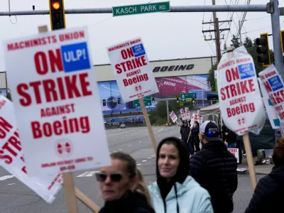 FILE - Boeing workers wave picket signs as they strike after union members voted to reject a contract offer near the company's factory in Everett, Washington, Sept. 15, 2024. (AP Photo/Lindsey Wasson)
