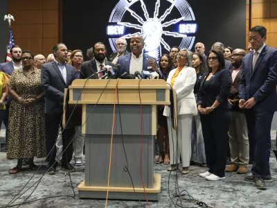 Democratic Texas Rep. Ron Reynolds, center, surrounded by other Texas House Democrats and Democratic members of Congress, speaks during a press conference at the Democratic Party in Warrenville, Ill., Monday, Aug. 4, 2025. (AP Photo/Nam Y. Huh)