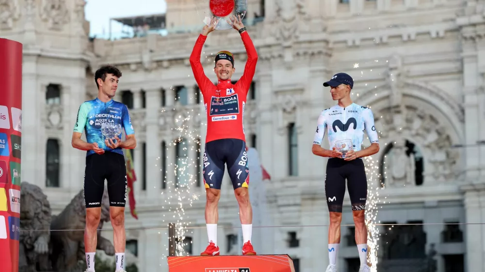 Cycling - Vuelta a Espana - Stage 21 - Madrid to Madrid - Spain - September 8, 2024 Red Bull - Bora - Hansgrohe's Primoz Roglic celebrates on the podium with a trophy after winning the Vuelta a Espana with second placed Decathlon AG2R La Mondiale Team's Ben O'connor and third placed Movistar Team's Enric Mas REUTERS/Isabel Infantes