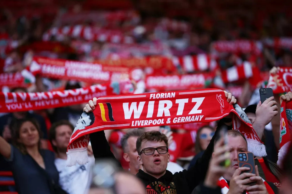 Soccer Football - Friendly - Liverpool v Athletic Bilbao - Anfield, Liverpool, Britain - August 4, 2025 A Liverpool fan holds a Florian Wirtz scarf REUTERS/Phil Noble