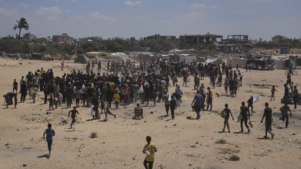 Palestinians rush to collect humanitarian aid airdropped by parachutes into Deir Al-Balah, in the central Gaza Strip, Tuesday, Aug. 5, 2025. (AP Photo/Abdel Kareem Hana)