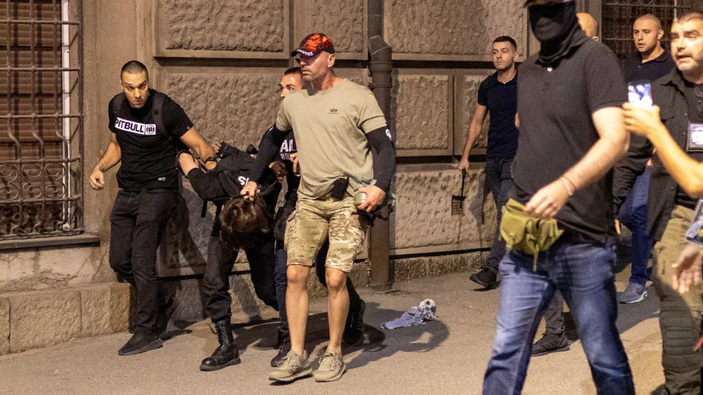 Serbian police officers wearing civilian clothing detain a person, during a standoff between supporters of the ruling party and anti-government protesters in Belgrade, Serbia, August 14, 2025. REUTERS/Djordje Kojadinovic