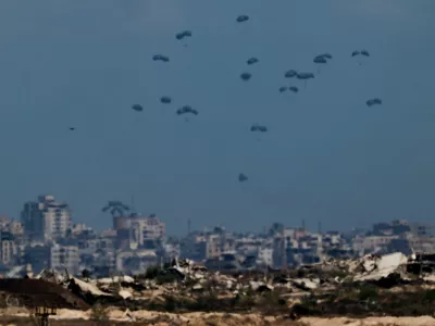 Humanitarian aid packages are airdropped over the Gaza Strip, as seen from Israel, August 5, 2025. REUTERS/Amir Cohen   TPX IMAGES OF THE DAY