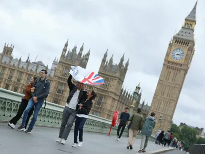 A person struggles to use their umbrella in the wind, as Storm Floris hits parts of Britain, near the Houses of Parliament in London, Britain, August 4, 2025. REUTERS/Toby Melville