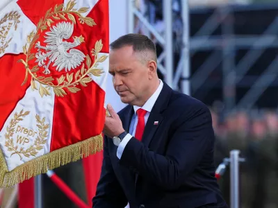 Newly sworn-in Polish President Karol Nawrocki kneels down in front of a flag as he attends the ceremony of accepting the sovereignty over the Armed Forces for the five-year term, in Warsaw, Poland, August 6, 2025. REUTERS/Aleksandra Szmigiel