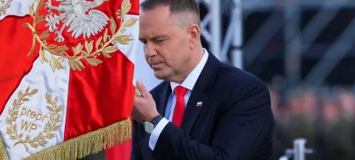 Newly sworn-in Polish President Karol Nawrocki kneels down in front of a flag as he attends the ceremony of accepting the sovereignty over the Armed Forces for the five-year term, in Warsaw, Poland, August 6, 2025. REUTERS/Aleksandra Szmigiel