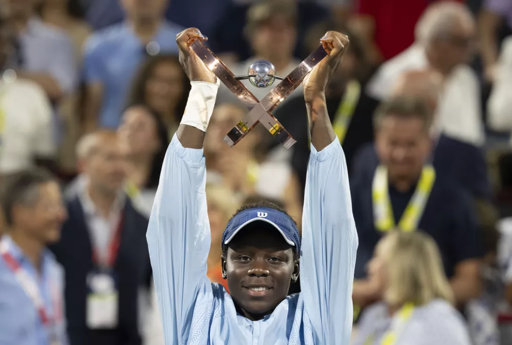 Victoria Mboko, of Canada, hoists the trophy following her win over Naomi Osaka, of Japan, in finals action at the National Bank Open women's tennis tournament in Montreal, Thursday, Aug. 7, 2025. (Christinne Muschi/The Canadian Press via AP)