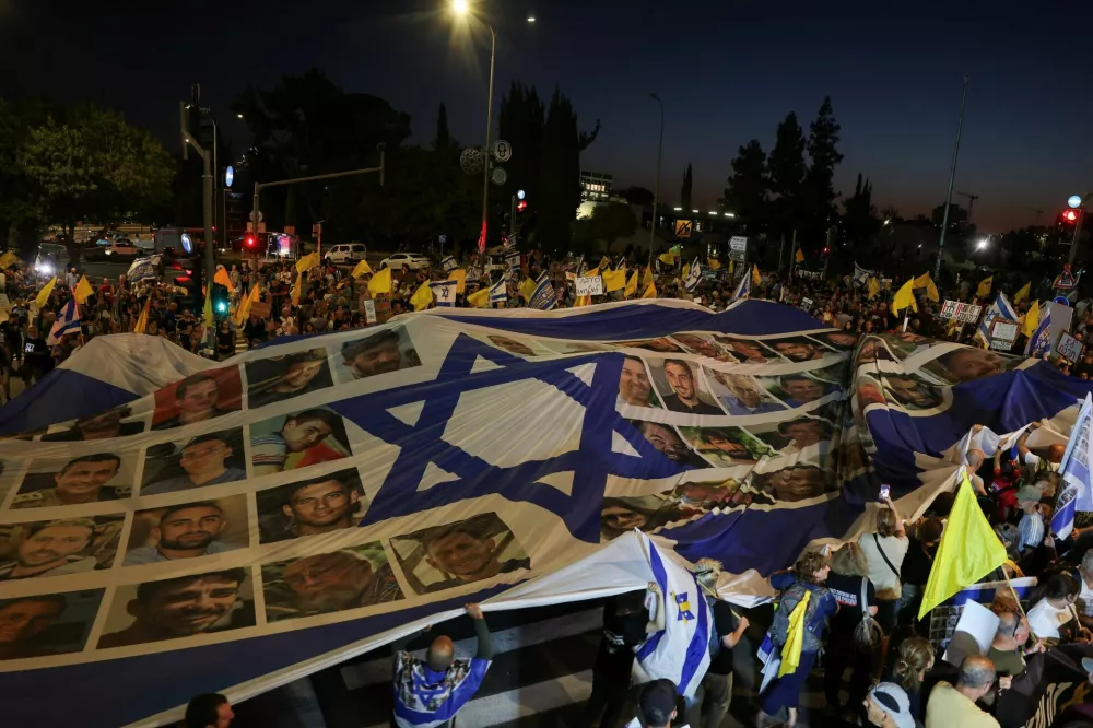 Demonstrators hold a banner, during a protest outside Israeli Prime Minister Benjamin Netanyahu's office, to demand the immediate release of the hostages kidnapped during the deadly October 7, 2023, attack on Israel by Hamas, and the end of the war, in Jerusalem, August 7, 2025. REUTERS/Ronen Zvulun