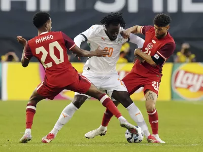 FILE - Canada's Ali Ahmed, left, and Jonathan Osorio, right, battle with Ivory Coast's Evann Guessand during first half Canadian Shield Tournament action, in Toronto, on Tuesday June 10, 2025. (Chris Young/The Canadian Press via AP, file)