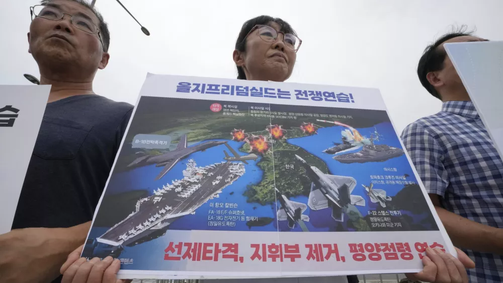 South Korean protesters attend a rally to oppose the planned joint military exercises called Ulchi Freedom Shield,or UFS, between the U.S. and South Korea, outside the presidential office in Seoul, South Korea, Monday, Aug. 11, 2025. The signs at bottom read, "Ulchi Freedom exercise is a war." (AP Photo/Ahn Young-joon)