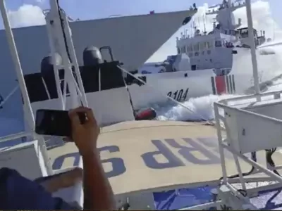 In this photo grab from video provided by the Philippine Coast Guard, a Chinese Navy vessel, left, accidentally collides with a Chinese Coast Guard ship, right, while chasing a Philippine fisheries boat, foreground, near Scarborough Shoal in the disputed South China Sea on Monday, Aug. 11, 2025. (Philippine Coast Guard via AP)