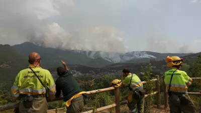 Firefighters wait for orders for deployment while monitoring a wildfire in the area of Voces from a viewpoint in Orellan, Spain, August 11, 2025. REUTERS/Violeta Santos Moura