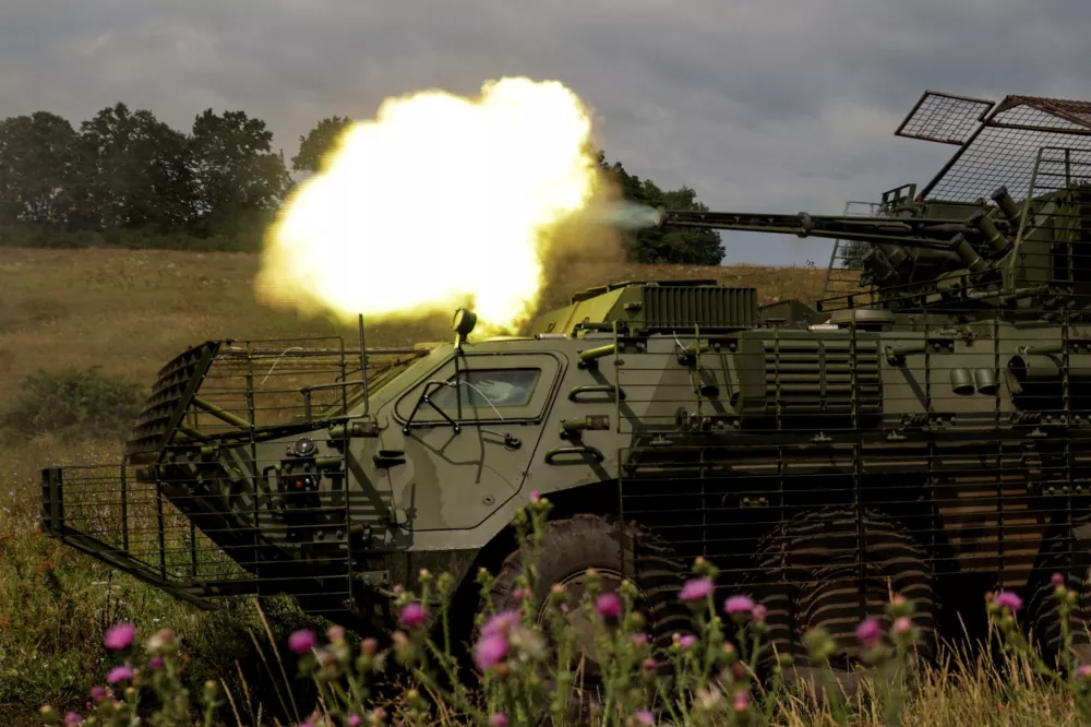 Service members of the 58th Separate Motorized Infantry Brigade of the Ukrainian Armed Forces fire a cannon of a BTR-4 armoured personnel carrier during military exercises at a training ground, amid Russia's attack on Ukraine, in Kharkiv region, Ukraine August 11, 2025. REUTERS/Sofiia Gatilova