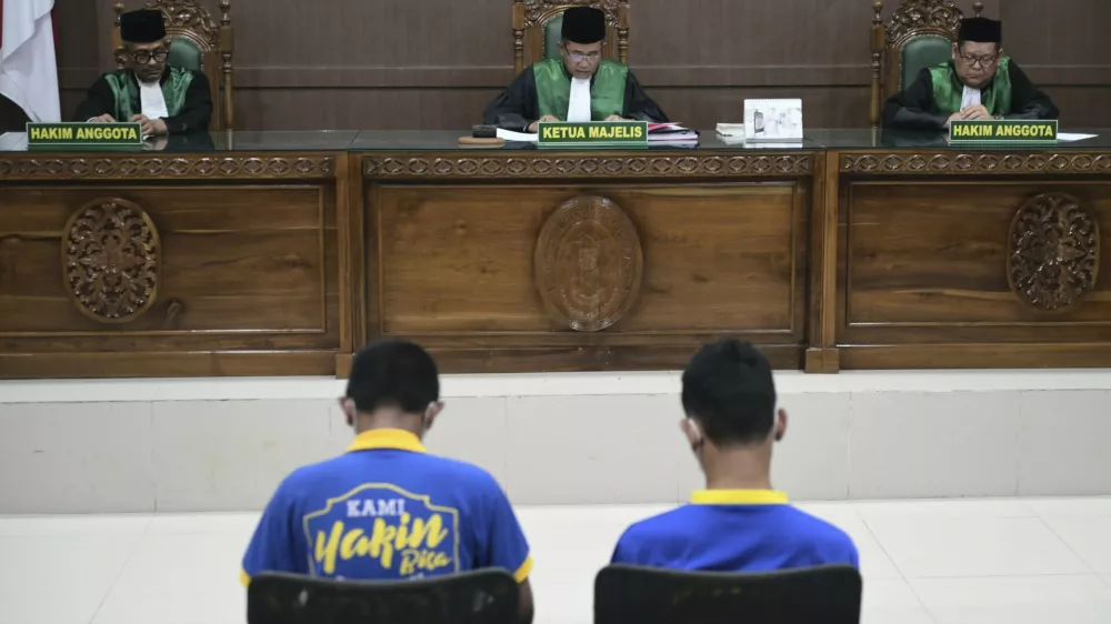 Chief Judge Rokhmadi, center, reads his verdict during the sentencing hearing for two men accused of having gay sex, at the Sharia Court in Banda Aceh, Indonesia, Monday, Aug. 11, 2025. (AP Photo/Reza Saifullah)