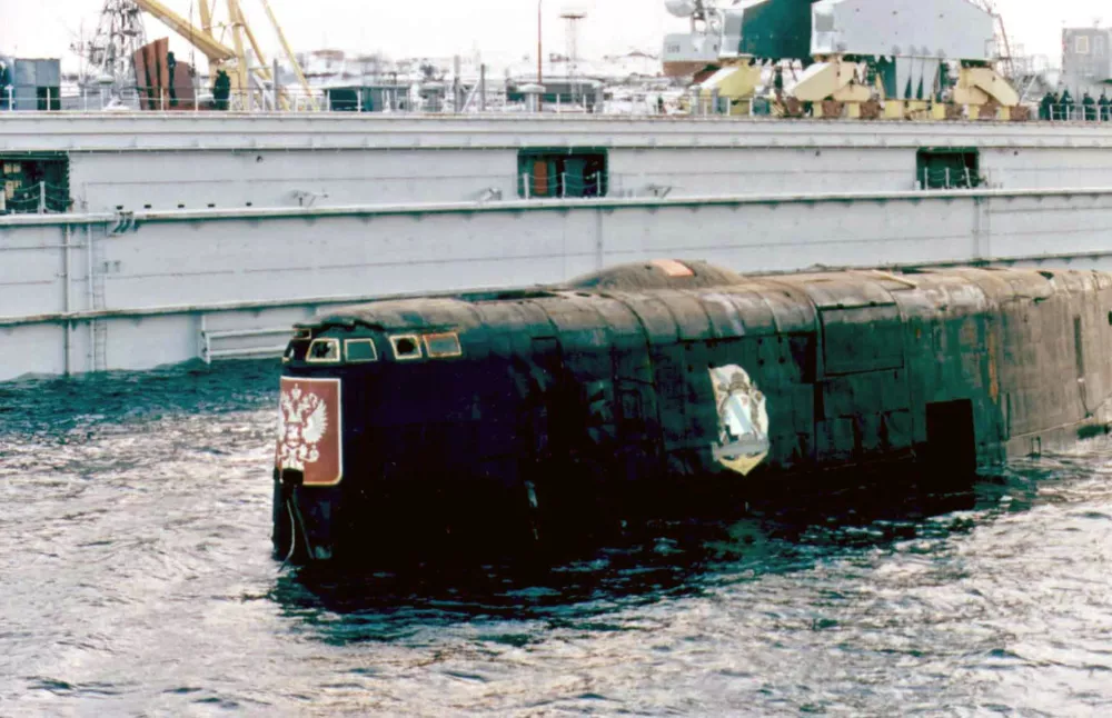 The conning-tower of the Kursk nuclear submarine surfaces in a dock ofRoslyakovo port near Murmansk, October 23, 2001. The barge which liftedKursk from the sea bed pulled out of the Arctic port of Roslyakovo onTuesday, leaving the vessel's carcass for investigators looking intoits mysterious sinking. REUTERS/PoolCVI/CLH/