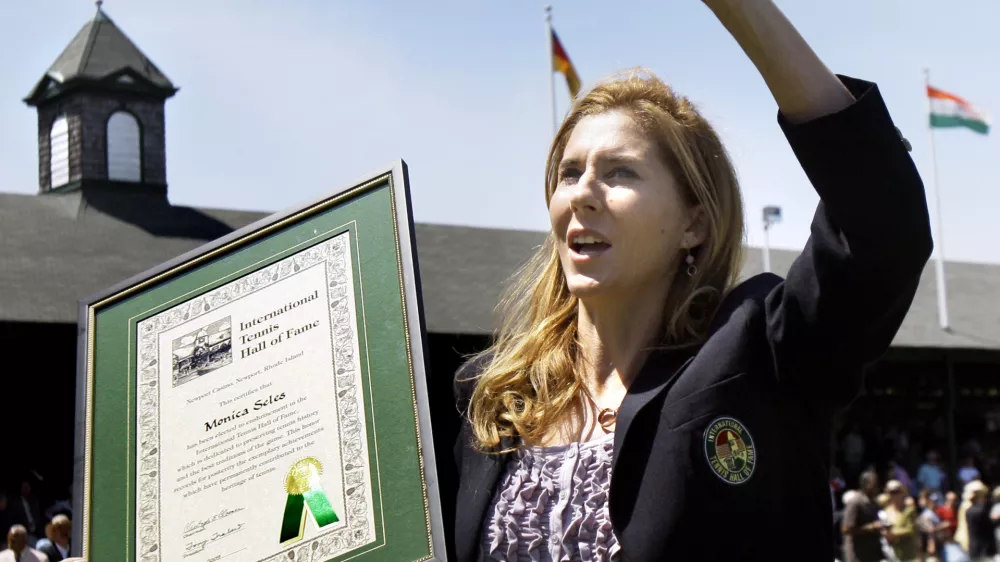 FILE - International Tennis Hall of Fame inductee Monica Seles waves to the crowd as she holds her plaque during ceremonies in Newport, R.I., July 11, 2009. (AP Photo/Elise Amendola, file)