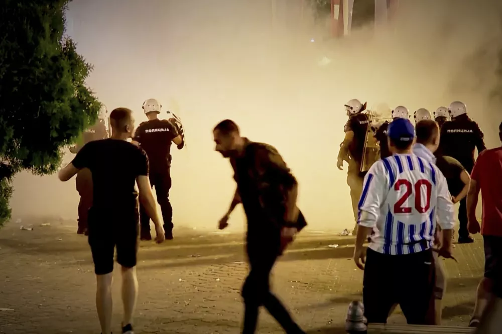 An image taken from video shows protesters and riot police engulfed by smoke as clashes erupted at protests in Vrbas, Serbia, Tuesday, Aug. 12, between opponents and supporters of the government in an escalation of tensions following more than nine months of persistent demonstrations against populist President Aleksandar Vucic. (N1 Serbia via AP)