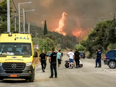 People watch as a wildfire burns in Achaia, Greece, August 12, 2025. Eurokinissi via REUTERS ATTENTION EDITORS - THIS PICTURE WAS PROVIDED BY A THIRD PARTY. NO RESALES. NO ARCHIVES. GREECE OUT. NO COMMERCIAL OR EDITORIAL SALES IN GREECE