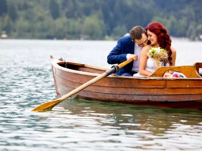 Young attractive wedding couple sharing love in a boat on beautiful lake / Foto: Jeliva